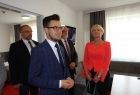 Grupa osób rozgląda się po pokoju.