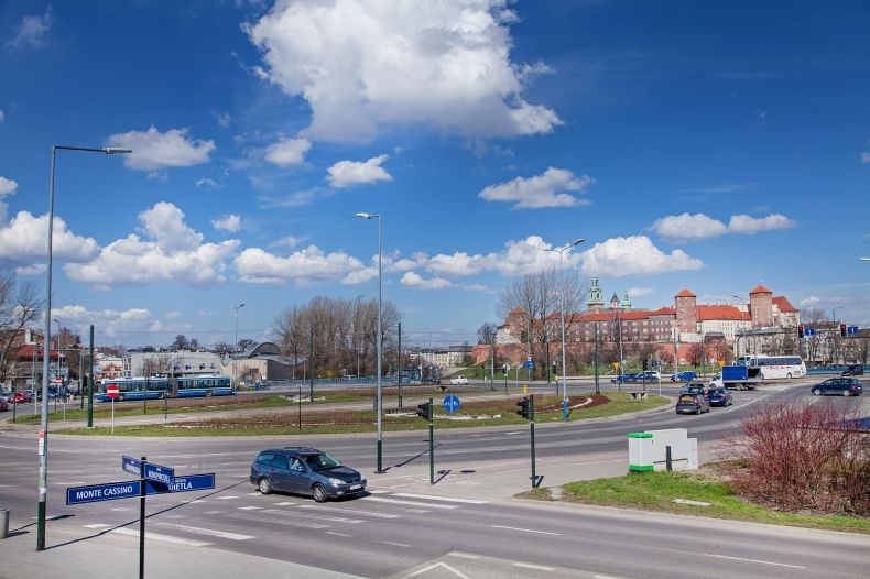 samochody poruszają się w ruchu okrężnych na rondzie w mieście. W tle niebieskie niebo