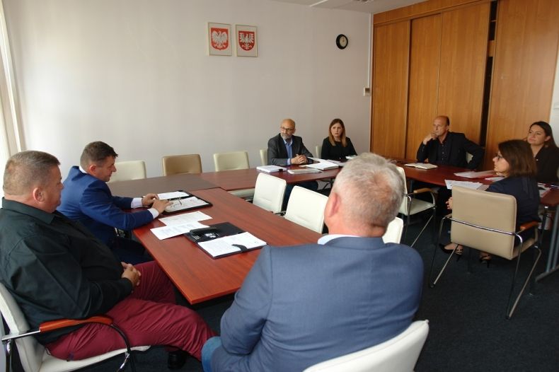 Grupa osób sziedzących przy stole w kształcie litery u.