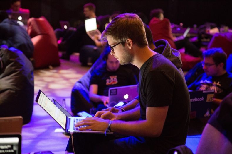 Mężczyzna pracujący na laptopie w trakcie wydarzenia typu hackathon