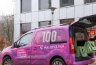 Różowy samochód akcji Dobro jest w Małopolsce, pracownik pakuje do środka paczki
