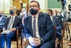 wicemarszałek Tomasz Urynowicz wraz z zaproszonymi gośćmi siedzi na krześle i słucha przemówienia rektora