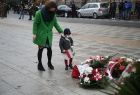 Kwiaty składają pozostałe delegacje będąc po lewej stronie zdjęcia. Po prawej stronie kadru kwiaty leżą przed pomnikiem.