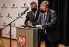 marszałek Witold Kozłowski przy mównicy z radnym Rafałem Stuglikiem 