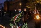 Mężczyzna składa kwiaty przed Krzyżem Katyńskim