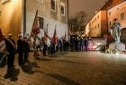 Widok z oddali na grupę uczestników obchodów rocznicowych oraz pomnik Jana Pawła II