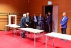 Kilka osób wizytuje salkę zaplecza. Trzy białe stoły odcinają się na tle czerwonej podłogi. Przedstawiciele Stowarzyszenia Europejskich Komitetów Olimpijskich złożyli wizytę w Tauron Arenie Kraków, wizytowali także Centrum Kongresowe ICE Kraków.