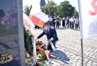 Mężczyzna składający kwiaty przed pomnikiem