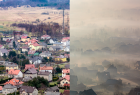 widok z góry na zabudowania, w połowie szerokości fotografii, przesłonięty przez smog