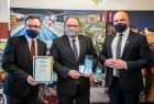 Norbert Rzepisko, burmistrz Skawiny, wicemarszałek Tomasz Urynowicz i radny Robert Bylica stoją z nagrodą eko-hero i okolicznościowym dyplomem