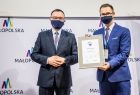 Dwóch mężczyzn stojących na tle banneru Małopolski, patrzących na wprost