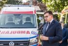 Uroczyste przekazanie karetek. Plac przed Krakowskim Pogotowiem Ratunkowym. Przemawia wojewoda Łukasz Kmita. W tle nowy ambulans