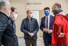 Wicemarszałek Łukasz Smółka rozmawia z czterema mężczyznami. Stoją w półkolu. Wszyscy w ochronnych maseczkach