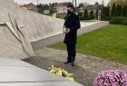 wicemarszałek Łukasz Smółka stoi przed pomnikiem upamiętniającym ofiary wypadków drogowych 