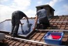 dwaj mężczyźni pracują na dachu, montując panele fotowoltaiczne