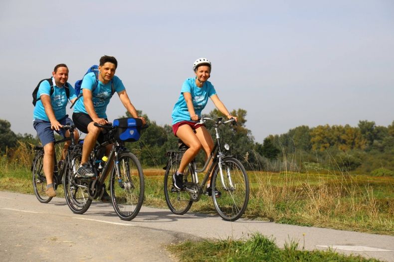 troje ludzi na rowerach jedzie ścieżką rowerową