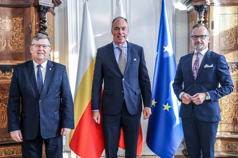 Marszałek Witold Kozłowski, Paul Schmit - ambasador Wielkiego Księstwa Luksemburga w Polsce oraz Szymon Malecki - konsul honorowy Wielkiego Księstwa Luksemburga w Krakowie. Zdjęcie pamiątkowe na tle flag