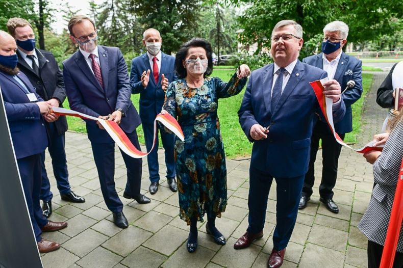 Elegancki mężczyzna z kobietą przecina wstęgę