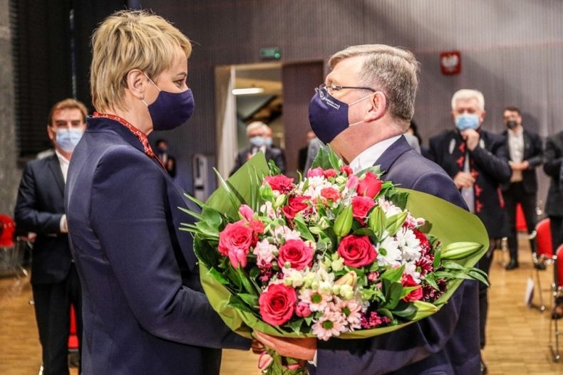 marszałek Witold Kozłowski gratuluje Iwonie Gibas z zarządu województwa, wręczając jej bukiet kwiatów