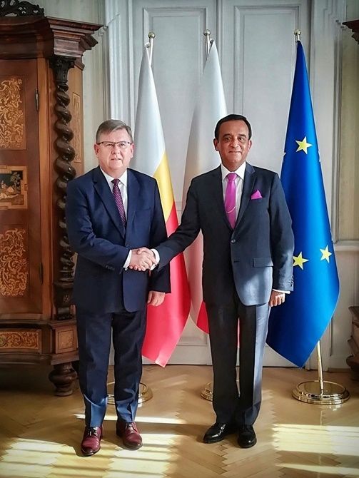 Pan Marszałek Witold Kozłowski wraz Ambasadorem Peru. Zdjęcie pamiątkowe na tle flag. Uścisk dłoni