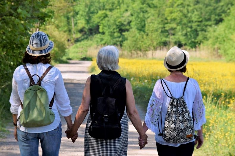 Zdjęcie przedstawia kobiety trzymające się za ręce