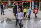 Wicemarszałek Łukasz Smółka bawi się z dziećmi przy parkowej fontannie.