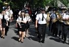 Orkiestra Dęta OSP w Głogoczowie maszeruje po ulicy i gra.