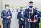 Wicemarszałek Łukasz Smółka przy mikrofonie podczas konferencji, w tle grupa gości wydarzenia