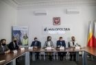 Grupa uczestników wideokonferencji przy stołach konferencyjnych