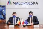 Marszałek Witold Kozłowski i wicemarszałek Łukasz Smółka podpisujący aneks przedłużający funkcjonowanie projektu Małopolski Tele-Anioł