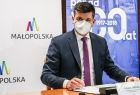 Wicemarszałek województwa małopolskiego Łukasz Smółka podpisujący protokół przekazania sprzętu i środków medycznych podarowanych Małopolsce przez Turyngię