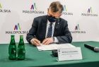 Marszałek województwa małopolskiego Witold Kozłowski podpisujący protokół przekazania sprzętu i środków medycznych podarowanych Małopolsce przez partnerską Turyngię