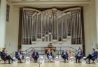 Uczestnicy debaty siedzą na fotelach na scenie