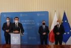 burmistrz Zakliczyna Dawid Chrobak, wojewoda Łukasz Kmita, marszałek Witold Kozłowski oraz wójt Stanisław Gorajczyk na tle niebieskiej ścianki i flag