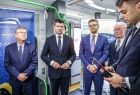 Marszałek Witold Kozłowski i wicemarszałek Łukasz Smółka stoją z innymi uczestnikami wydarzenia wewnątrz nowego pociągu.
