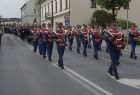 Orkiestra Dęta z Kleczy w strojach paradnych idzie ulicą.