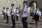 Strażacka Orkiestra Dęta Filipowice stoi, w tle zabytkowy mur Jasnej Góry.