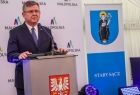 Marszałek Witold Kozłowski stoi przy mównicy, z przodu herb Małopolski.