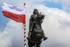 Pomnik króla Władysława Jagiełły, obok biało czerwona flaga Polski.
