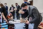 Wicemarszałek Łukasz Smółka w towarzystwie dziecka w stroju regionalnym.