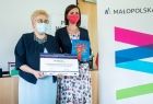 Marta Malec-Lech z zarządu województwa przekazuje promesę beneficjentom.