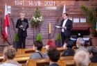 Na scenie stoi ojciec franciszkanin i prowadzący koncert.