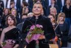 Solista chóru stojący wśród ludzi.