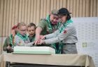 Uczestnicy - harcerze kroją urodzinowy tort