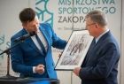 marszałek Witold Kozłowski oraz dyrektor szkoły, który wręcza zdjęcie oprawione