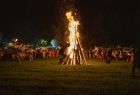 wysokie ognisko na polanie. wokół tańczący górale