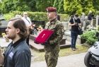 żołnierz niesie odznaczenie - krzyż na czerwonej poduszce