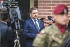 Piotr Duda z Solidarności przemawia do mikrofonu, na pierwszym planie żołnierz