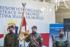 Trzej żołnierze na tle płótna w kolorach flagi RP, z napisem "Święto Terenowych Organów Administracji Wojskowej Województwa Małopolskiego"