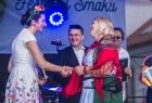 Marta Malec-Lech z zarządu województwa stoi na scenie i składa gratulacje.